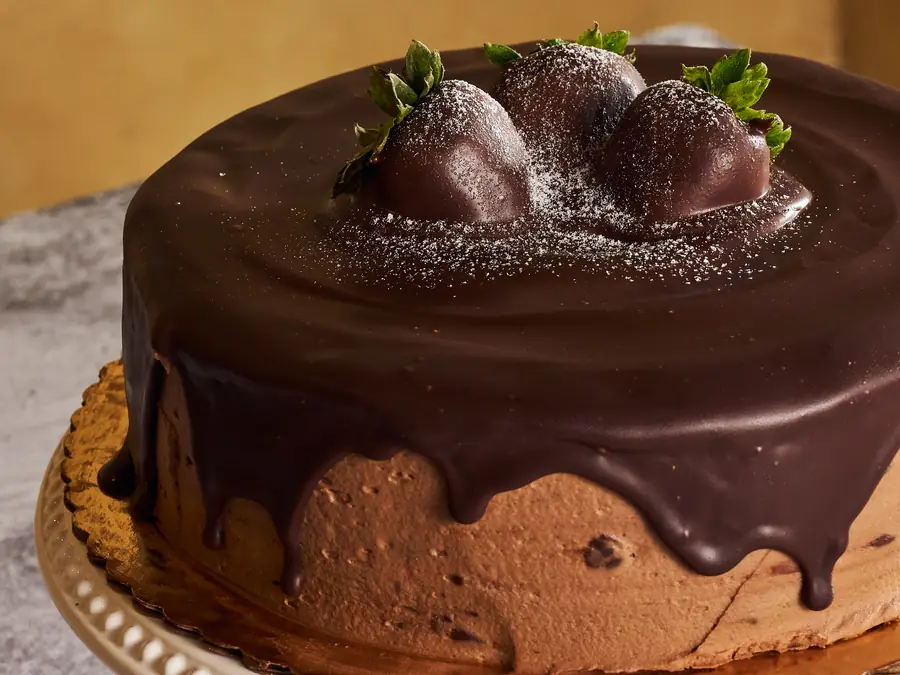 Chocolate ganache cake topped with chocolate-dipped strawberries